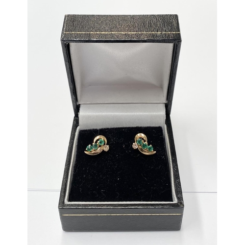 143 - AN ELEGANT PAIR OF 14CT YELLOW GOLD EMERALD & DIAMOND CROSSOVER STYLE EARRINGS; each earring with 3 ... 