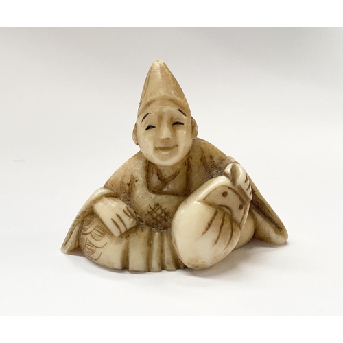 148 - A 19TH CENTURY CARVED IVORY NETSUKE OF A SEATED MAN, robed & wearing a hat, with finely carved detai... 