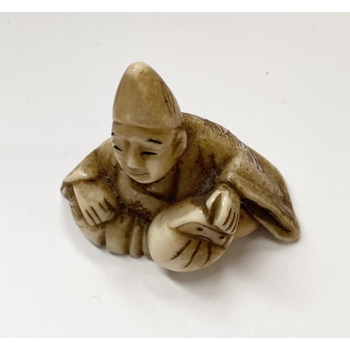 148 - A 19TH CENTURY CARVED IVORY NETSUKE OF A SEATED MAN, robed & wearing a hat, with finely carved detai... 