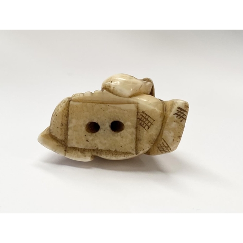 148 - A 19TH CENTURY CARVED IVORY NETSUKE OF A SEATED MAN, robed & wearing a hat, with finely carved detai... 