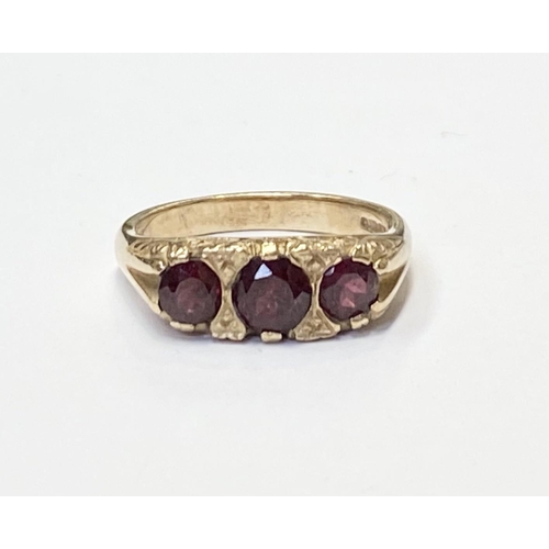 182 - A 9CT YELLOW GOLD THREE STONE GARNET RING, the garnets are set in a super detailed mount , ring size... 