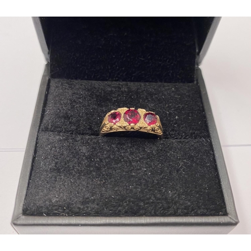 182 - A 9CT YELLOW GOLD THREE STONE GARNET RING, the garnets are set in a super detailed mount , ring size... 