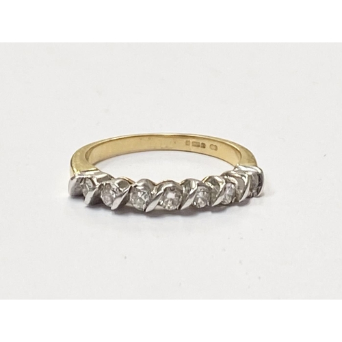 184 - AN 18CT YELLOW GOLD SEVEN STONE DIAMOND RING, the seven diamonds are set in a white gold swirl setti... 