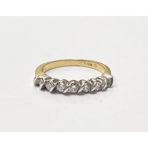 184 - AN 18CT YELLOW GOLD SEVEN STONE DIAMOND RING, the seven diamonds are set in a white gold swirl setti... 