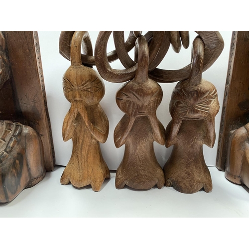 198 - AN ASSORTED COLLECTION OF CARVED WOODEN AFRICAN PIECES, to include (i) a pair of carved wooden booke... 