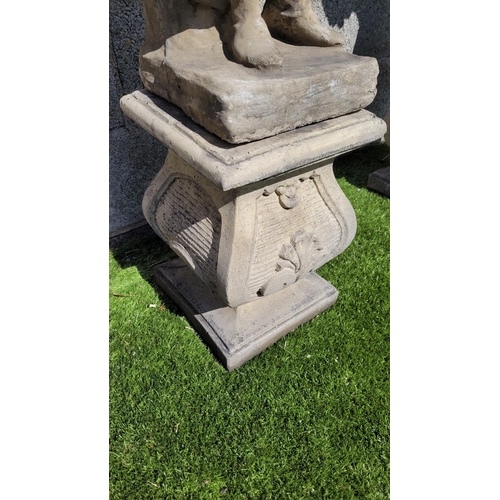 216 - A GARDEN ORNAMENT IN THE FORM OF A FIGURE, 	the stone composite figure stands upon a shaped base, in... 