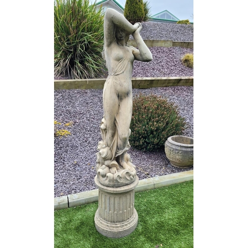 226 - A GARDEN ORNAMENT IN THE FORM OF A FEMALE FIGURE, 	the woman stands upon a column shaped base, her a... 