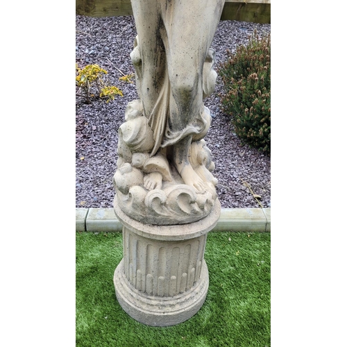 226 - A GARDEN ORNAMENT IN THE FORM OF A FEMALE FIGURE, 	the woman stands upon a column shaped base, her a... 