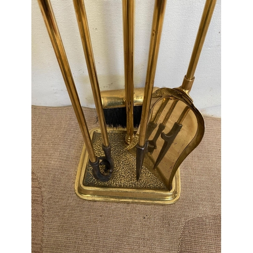 246 - A SET OF FOUR BRASS FIRE IMPLEMENTS ON STAND, to include shovel, brush, poker and tongs, each with d... 