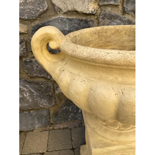 247 - A PAIR OF GARDEN URNS ON STANDS, urns with two handles, fluted base, supported by rectangular plinth... 