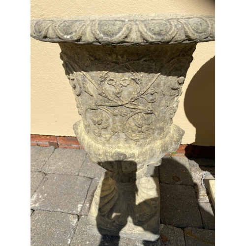 250 - A PAIR OF STONE GARDEN URNS, finely decorated with fluted and floral detail, raised on square base. ... 