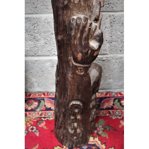 286 - A FIGURATIVE WOODEN SCULPTURAL CARVING, showing a figure with its hands raised above the head held i... 