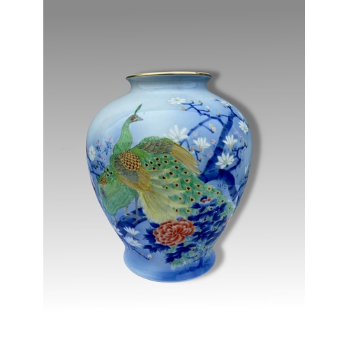 29 - A VIBRANT POT SHAPED PORCELAIN VASE, decorated with brightly coloured peacocks and blossoms on a lig... 