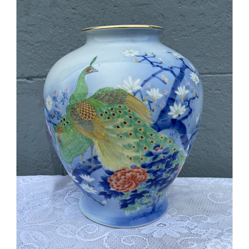 29 - A VIBRANT POT SHAPED PORCELAIN VASE, decorated with brightly coloured peacocks and blossoms on a lig... 