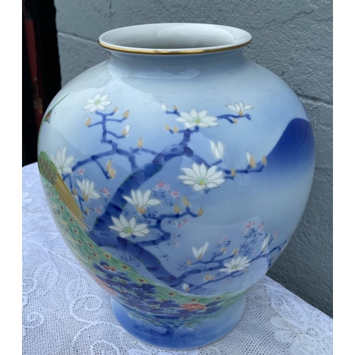 29 - A VIBRANT POT SHAPED PORCELAIN VASE, decorated with brightly coloured peacocks and blossoms on a lig... 