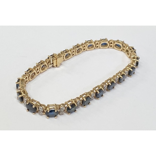 62 - A STUNNING 14CT YELLOW GOLD SAPPHIRE & DIAMOND TENNIS BRACELET, made up of 20 oval faceted sapphire ... 