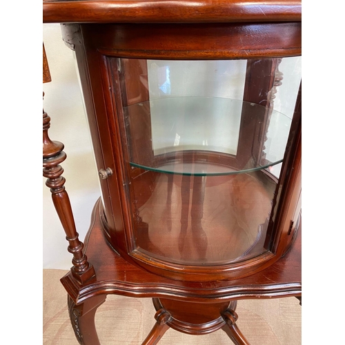 68 - AN UNUSUAL CIRCULAR MAHOGANY DISPLAY CABINET, bow fronted glass to front, with two turned supports, ... 