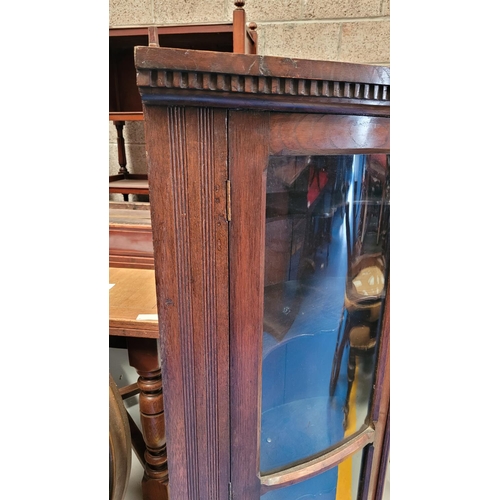 72 - A VERY FINE ANTIQUE OAK BOW FRONTED GLAZED CORNER CABINET, carved dentil edge to the top and reeded ... 