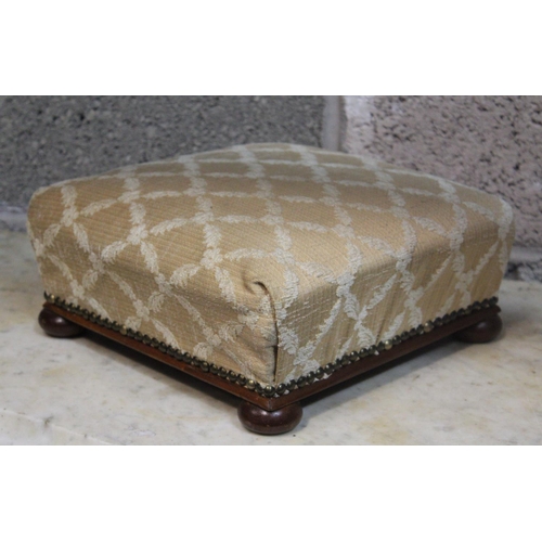 79 - A PAIR OF LOW RISE FOOT RESTS, 	each with stuffed over cushion, nicely upholstered, resting on bun f... 