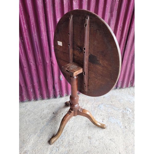 91 - AN 18TH CENTURY TIP UP CENTRE TABLE, with oak top and fruit wood base, a column support on a tripod ... 