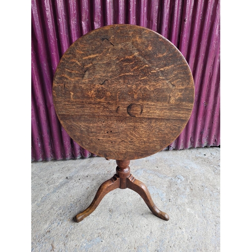 91 - AN 18TH CENTURY TIP UP CENTRE TABLE, with oak top and fruit wood base, a column support on a tripod ... 