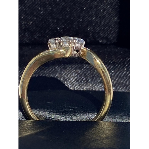 122 - AN ELEGANT 18CT YELLOW GOLD THREE STONE DIAMOND RING, hand-made, with wave design shoulders featurin... 