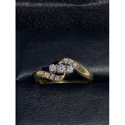 122 - AN ELEGANT 18CT YELLOW GOLD THREE STONE DIAMOND RING, hand-made, with wave design shoulders featurin... 