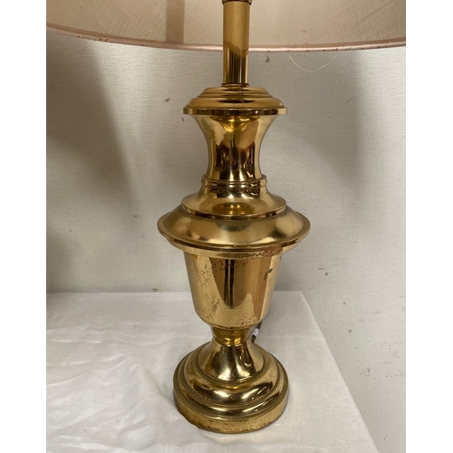 135 - A PAIR OF HEAVY BRASS LAMPS, with shaped polished brass body on circular platform base, with cream l... 