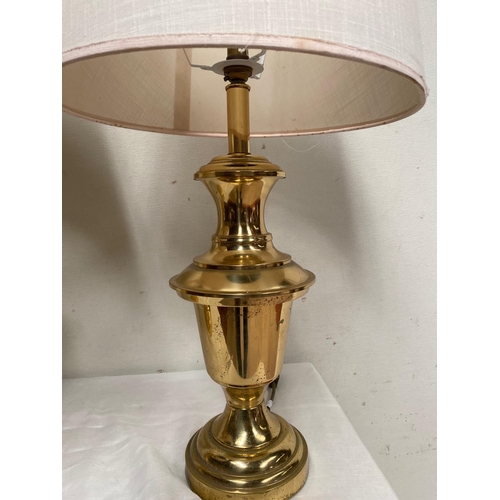 135 - A PAIR OF HEAVY BRASS LAMPS, with shaped polished brass body on circular platform base, with cream l... 