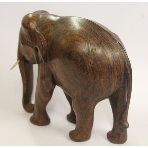 151 - A CARVED TEAK ELEPHANT , with ivory tusks attached, with a heavy weight, possibly of South East Asia... 