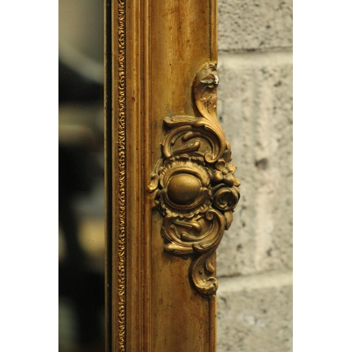 202 - AN ANTIQUE GILT WALL MIRROR, 	shaped in a rectangular form; this gilt mirror is beautifully adorned ... 