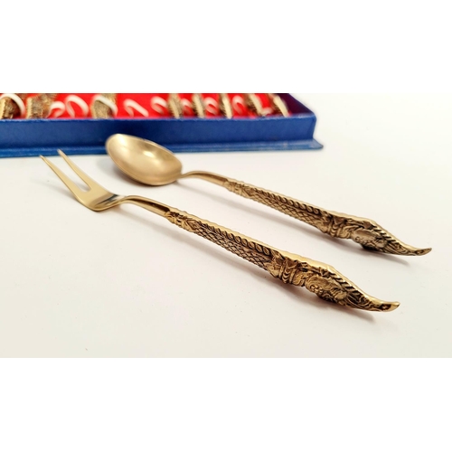 216 - A BOXED SET OF BRASS CUTLERY; includes 6 two prong forks, 6 spoons; each with very decorative handle... 