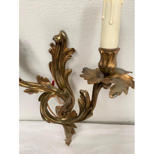 43 - AN ART NOUVEAU STYLE BRASS WALL SCONCE, highly decorated with shaped scrolls, with two electrified c... 