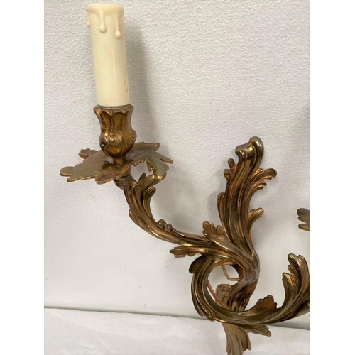 43 - AN ART NOUVEAU STYLE BRASS WALL SCONCE, highly decorated with shaped scrolls, with two electrified c... 