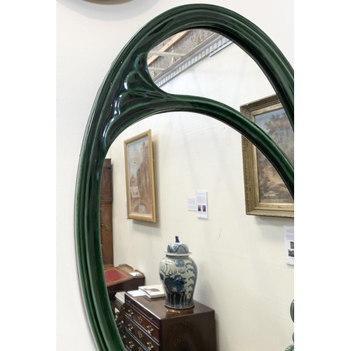 50 - AN ART NOUVEAU CERAMIC OVAL WALL MIRROR, fluted green ceramic frame with scrolling details, Dimensio... 