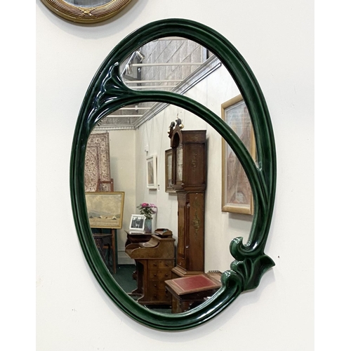 50 - AN ART NOUVEAU CERAMIC OVAL WALL MIRROR, fluted green ceramic frame with scrolling details, Dimensio... 