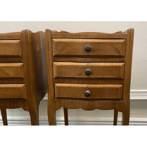 51 - A PAIR OF FRENCH STYLE FIGURED BEDSIDE CABINETS, with three drawers, crossbanding and shaped gallery... 