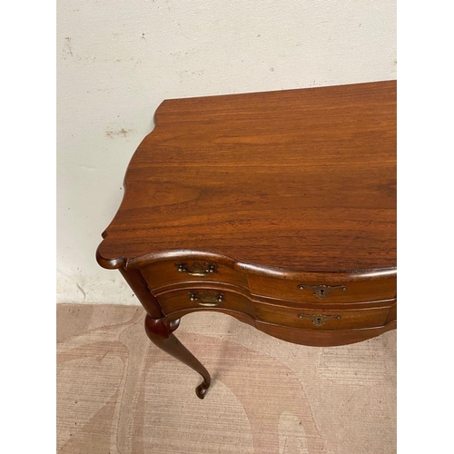 10 - A QUEEN ANNE STYLE WALNUT DESK, serpentine front with two drawers having brass handles, supported by... 