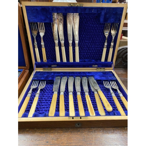 112 - A PAIR OF CASED SILVER PLATED CUTLERY SETS, case with gilt cartouche to top, opening to engraved fis... 