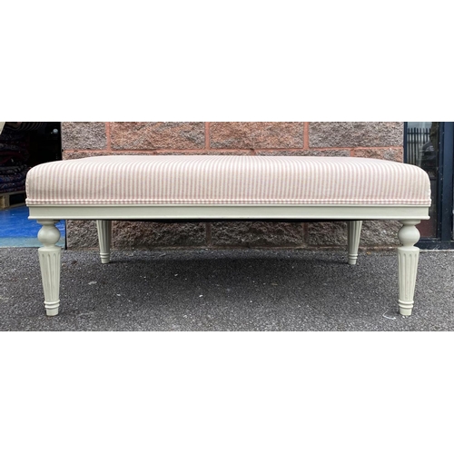 128 - AN UPHOLSTERED OTTOMAN BENCH, upholstered with pale striped fabric, standing on turned leg, painted ... 