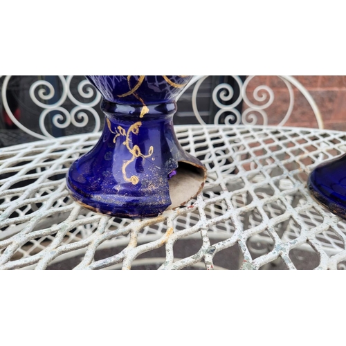 138 - A PAIR OF DECORATIVE BLUE PICTURE VASES, with floral design, some damage to the base of one as photo... 