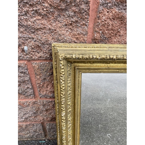 15 - AN ANTIQUE GILT WALL MIRROR, rectangular form, ornately carved with foliate design, dimensions: 66cm... 