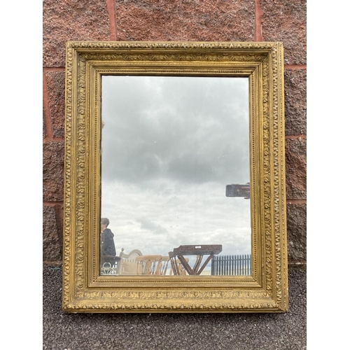 15 - AN ANTIQUE GILT WALL MIRROR, rectangular form, ornately carved with foliate design, dimensions: 66cm... 