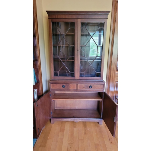 154 - A 20TH CENTURY TWO DOOR GLAZED BOOKCASE/CABINET, with dentil detail to the top over double astragal ... 