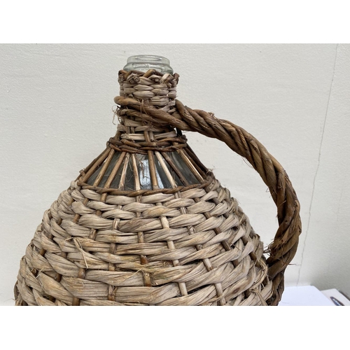 160 - A VINTAGE FRENCH WICKER HANDLED DEMIJOHN WINE BOTTLE, glass bottle in woven wicker cover, used to pr... 