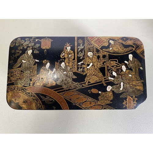 19 - AN EARLY 20TH CENTURY CHINOISERIE BLACK LACQUER AND GILT TEA CADDY, of rectangular form with rounded... 