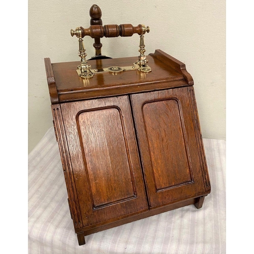 27 - AN UNIQUE OAK TWO DOOR COAL SCUTTLE, with slope front, decorative turned brass handle to top, brush ... 