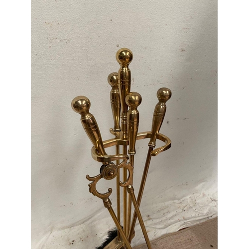 36 - A BRASS COMPANION SET, on stand, to include brush, tongs, poker and shovel.