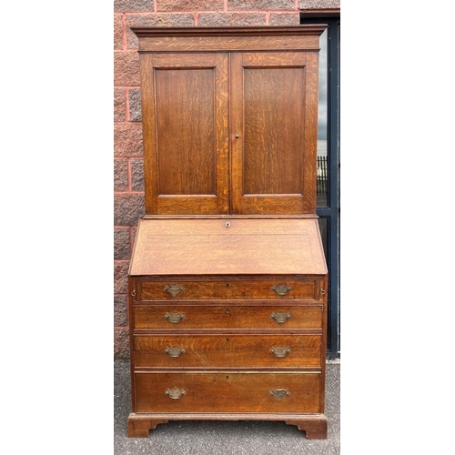 41 - A FINE GEORGIAN BUREAU BOOKCASE, with fluted cornice, two panelled doors above fold out desk with fi... 