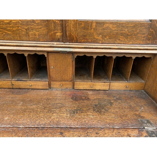 41 - A FINE GEORGIAN BUREAU BOOKCASE, with fluted cornice, two panelled doors above fold out desk with fi... 